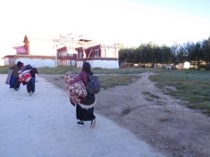 women walking on path outside monastery