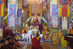 monks sitting in decorated altar room