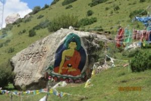 painted of buddha on side of large rock
