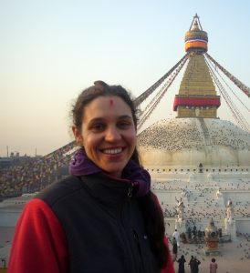 portrait of brown haired woman in front of large stupa