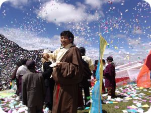 monk smiling in cloud of confetti