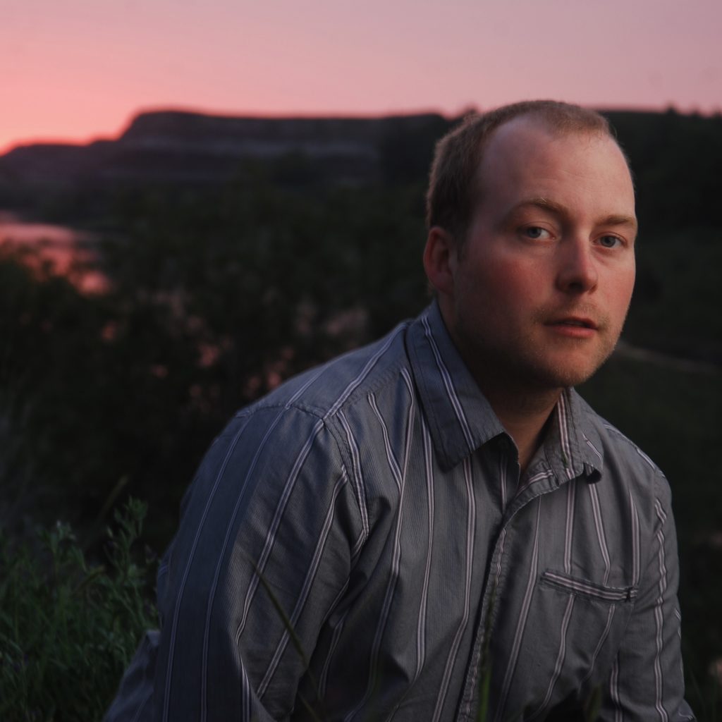 portrait of brown haired man in striped shirt