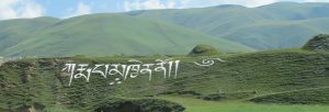 Karmapa Khyeno made from white rocks on the hillside near the entrance to Begun Monastery