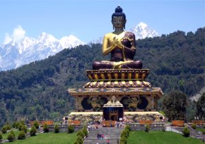 large buddha monument with view of himalayas in distance