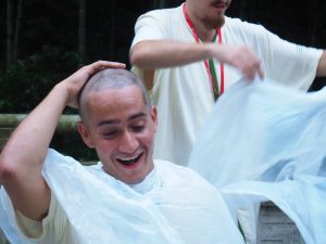 man in white holding head and laughing
