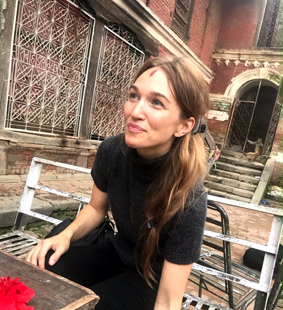 brown haired woman with bindi looking away from camera