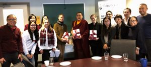 students and professors posing with visiting monk