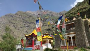 prayer flags, monastery, and mountain range