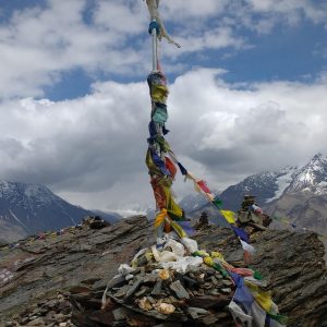 pillar atop mountain wrapped in prayer flags