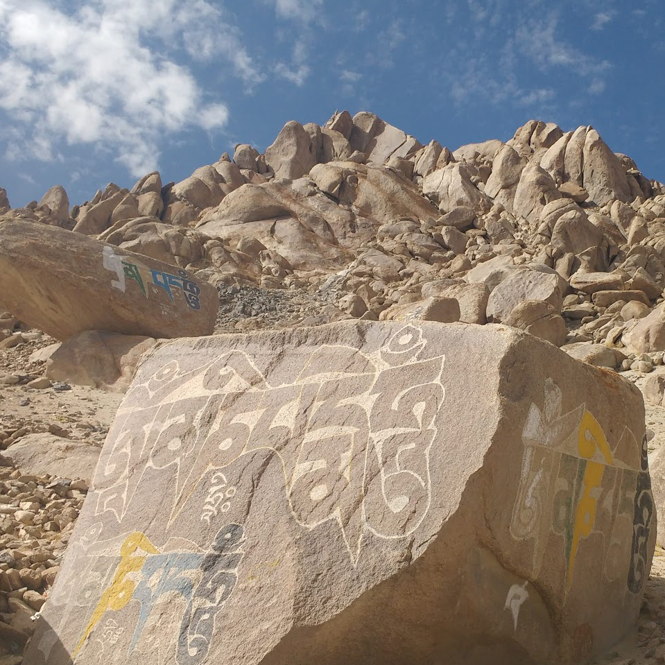 mani stones at base of rocky hill