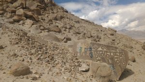 mani stone at base of rocky hill