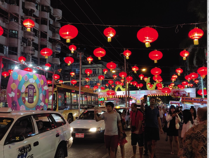 red lanterns strung above busy street glowing at night