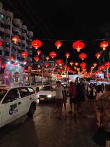 red lanterns strung above busy street glowing at night