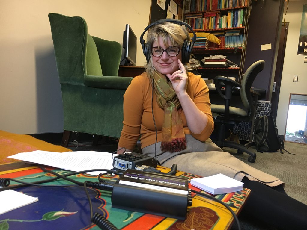 Woman seated on the floor wearing headphones